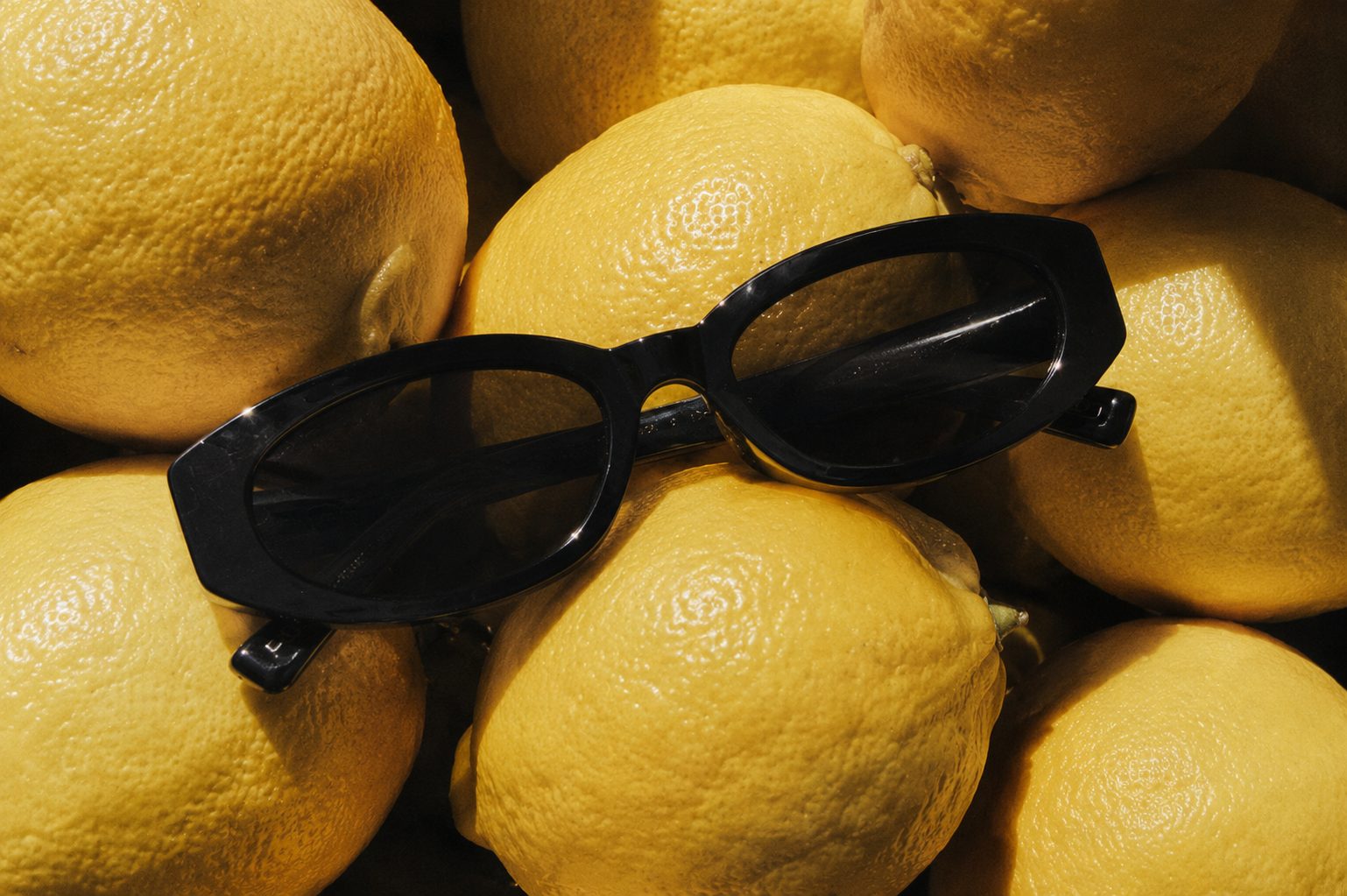 Black sunglasses on lemons — close up